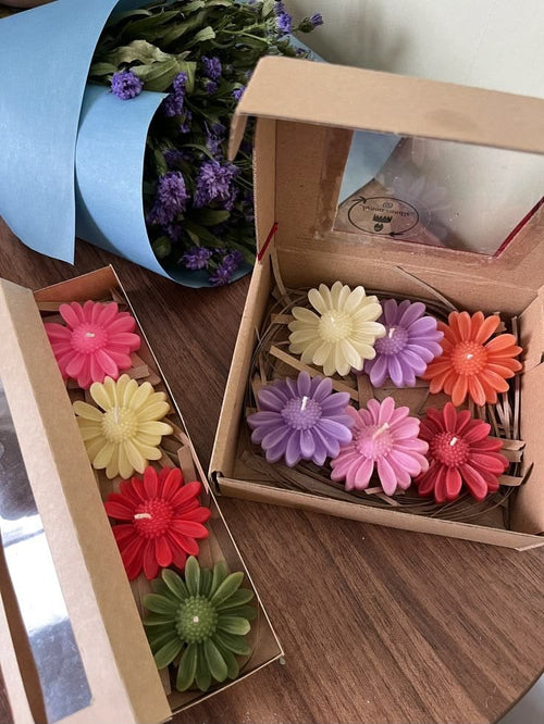 Cajas con velitas de colores en forma de margaritas