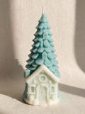 Árbol navideño celeste con casita clara en la base